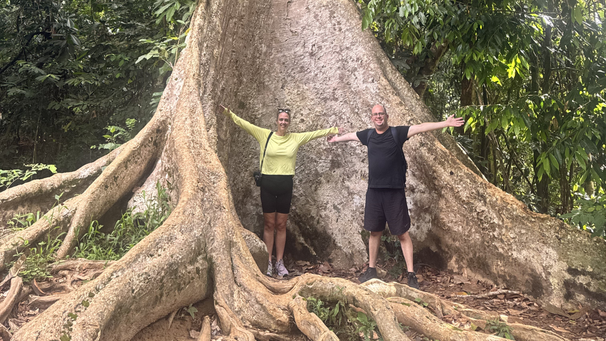Megan and Darryl standing in front of a large tree trunk in the Taman Negara National Park