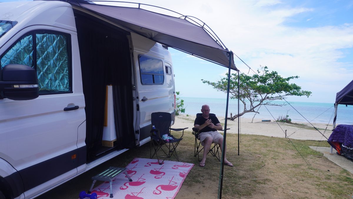 Darryl sitting under It Zwibble's awning at the beach